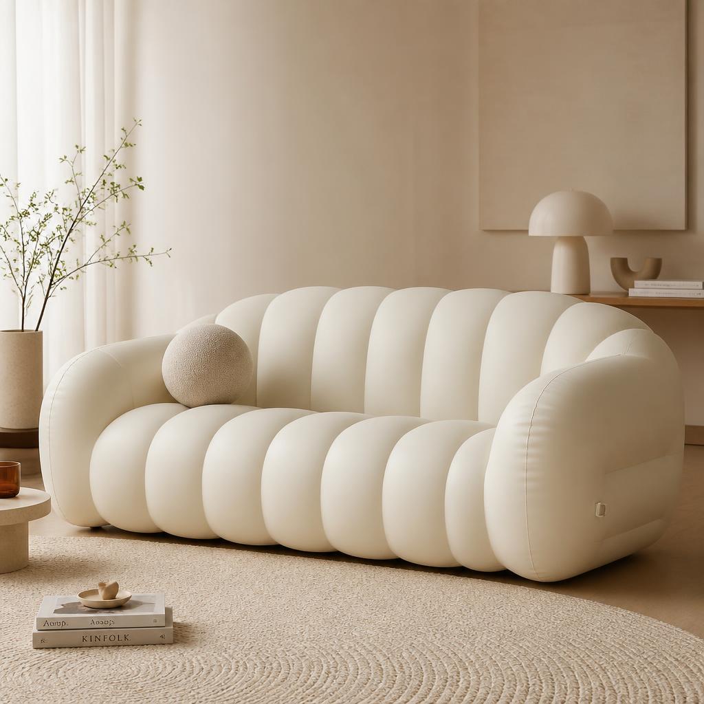 Cream puffy inflatable three-seat sofa in a warm minimal room