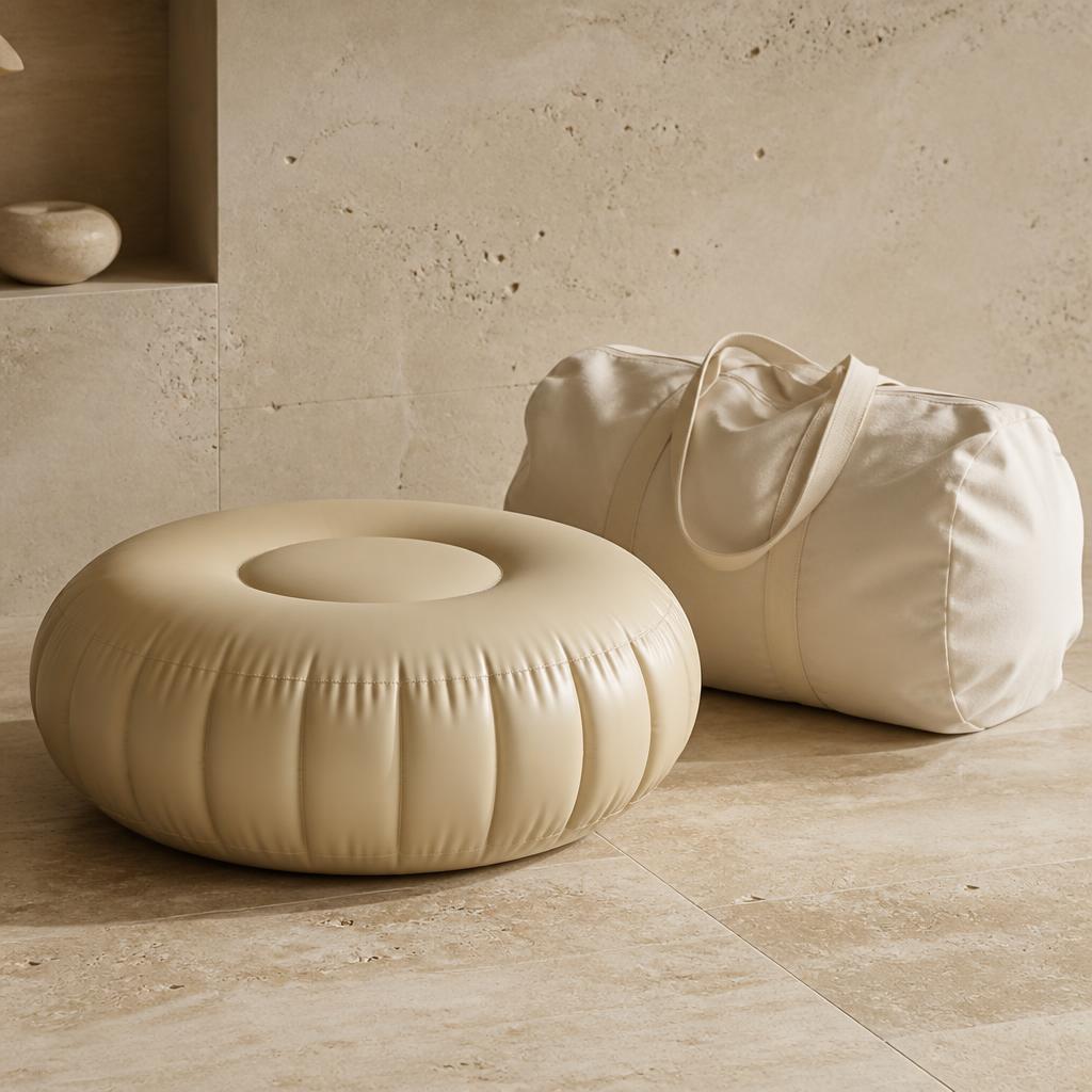Round sand-coloured inflatable pouf beside a cream canvas carry bag